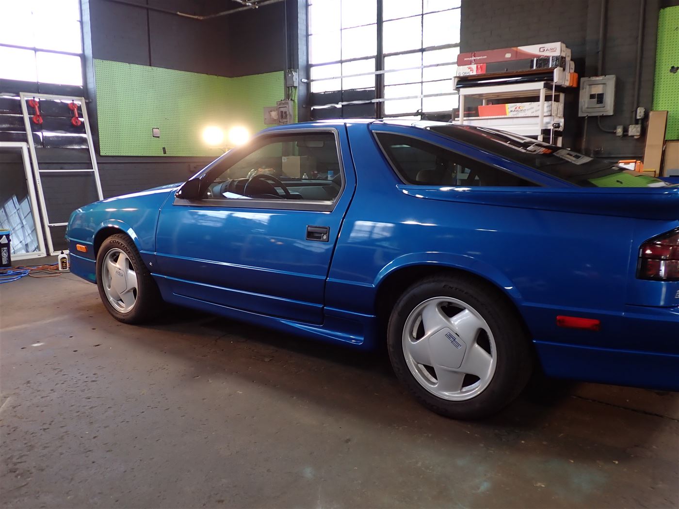 Blue Dodge Daytona Shelby in the shop with Autobahn film racks
